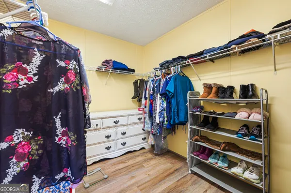 a view of walk in closet with clothes and shoes
