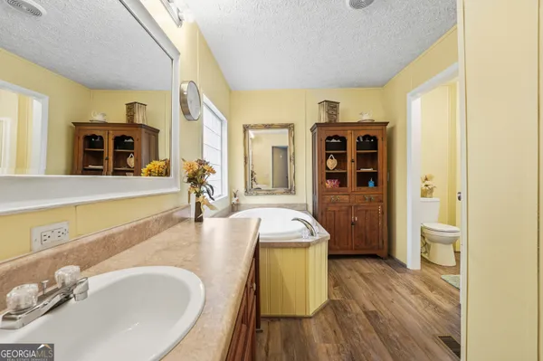 a spacious bathroom with a granite countertop sink and a mirror