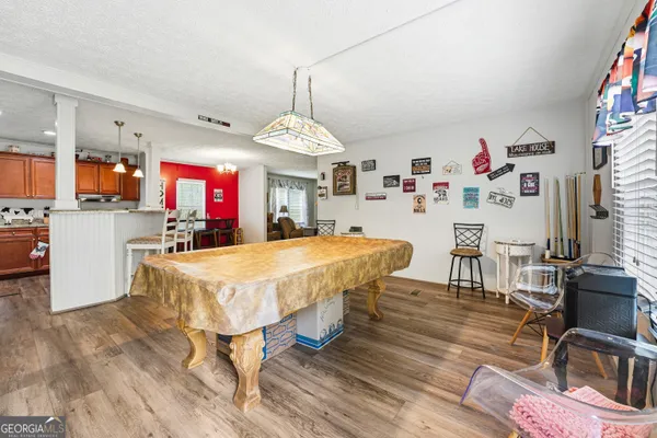 a very nice looking dining room with kitchen island stainless steel appliances furniture a fireplace and a flat screen tv