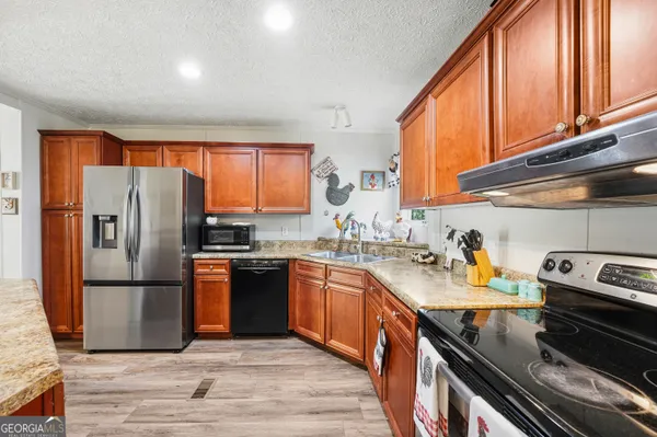 a kitchen with stainless steel appliances granite countertop a refrigerator stove and sink