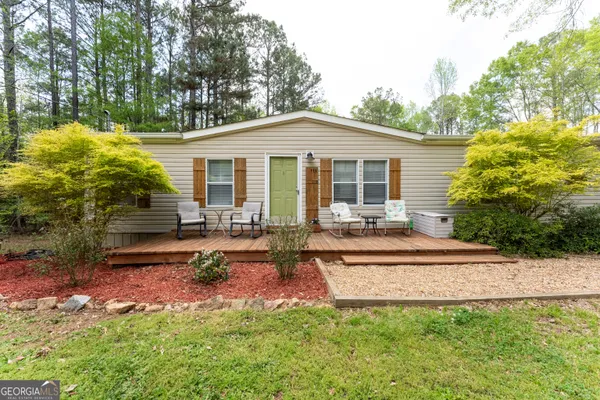 a view of a house with backyard and sitting area