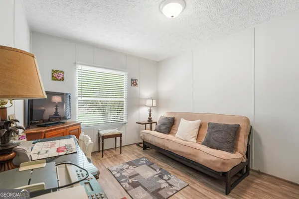 a living room with furniture a flat screen tv and a window