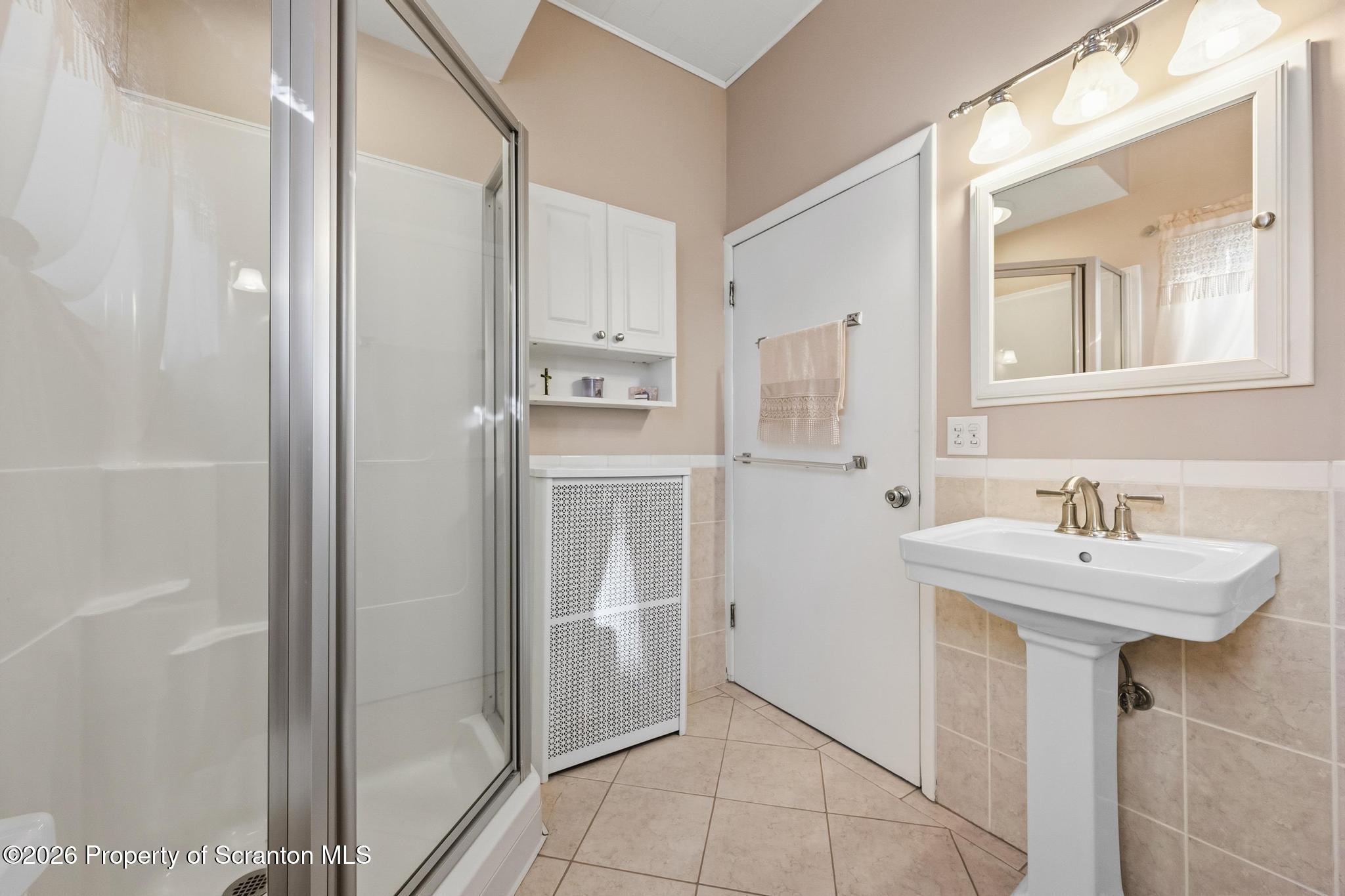 616 Myrtle Street Scranton, PA 18510 - Photo 33 of 65 a bathroom with a sink a mirror and shower