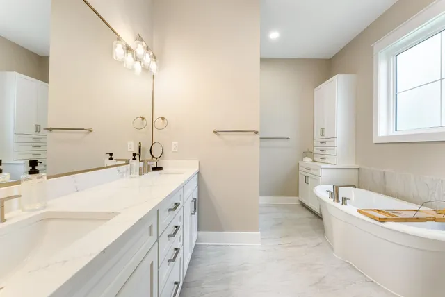 a bathroom with a tub sink and mirror