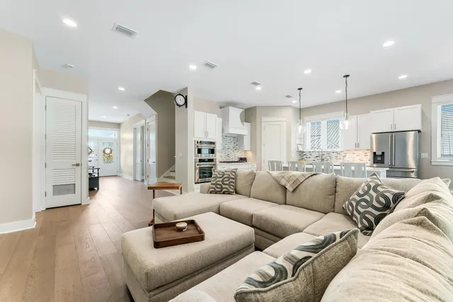 a living room with furniture and a view of kitchen