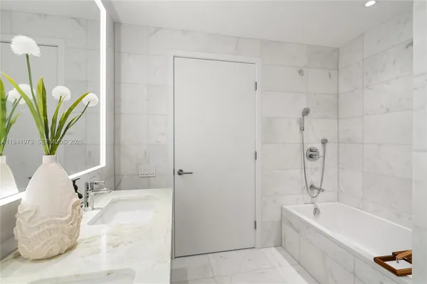 a living room with a bed and dresser with mirror