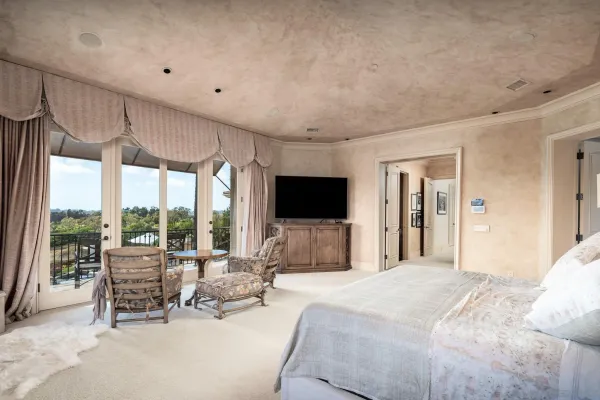 a spacious bedroom with a large bed and a flat screen tv
