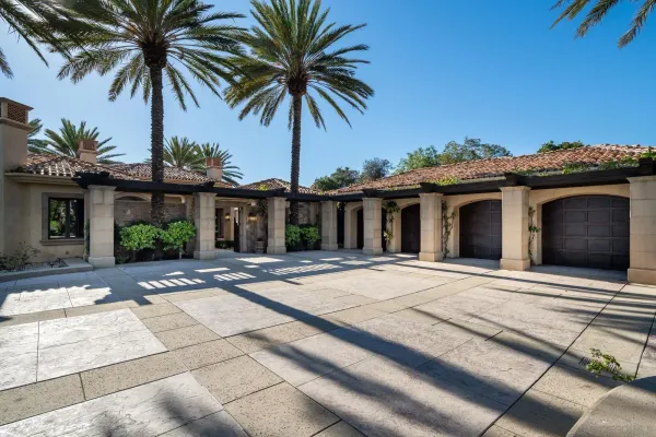 a view of a house with a yard and palm trees