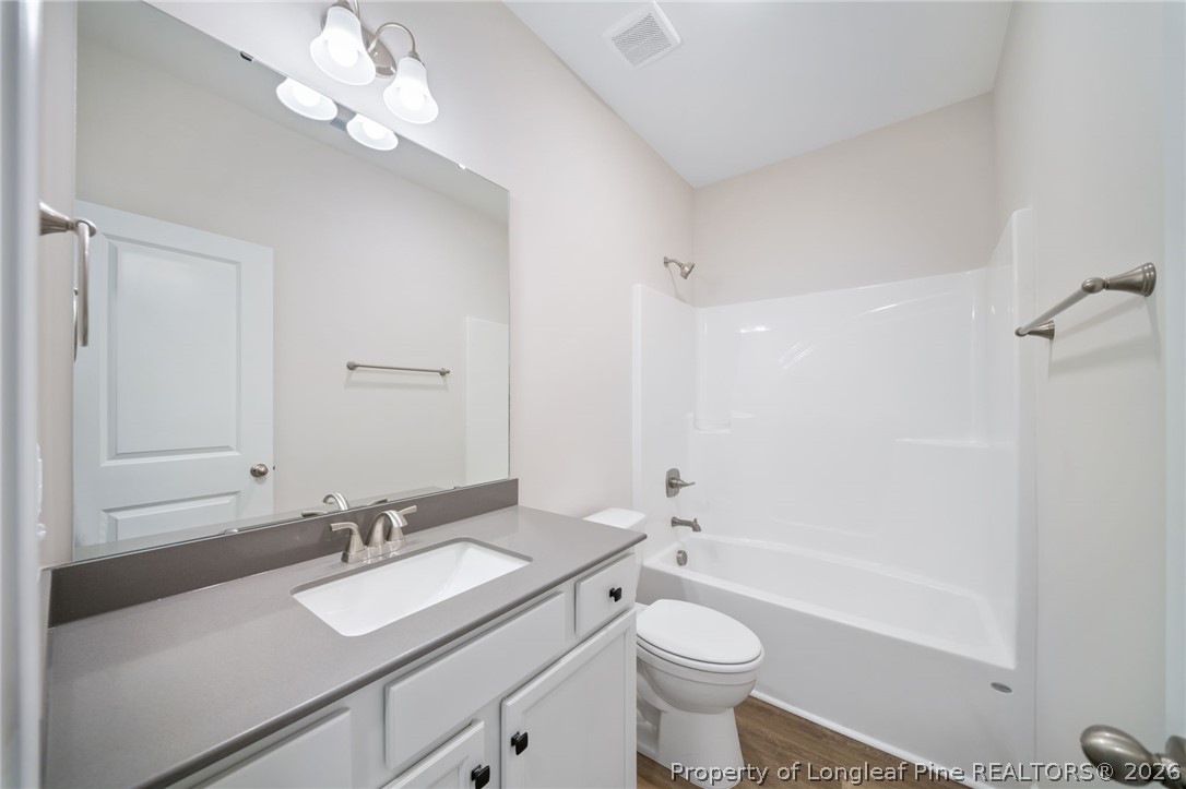 4052 Lofton Street Wade, NC 28395 - Photo 15 of 22 a bathroom with a sink a toilet a large mirror and shower