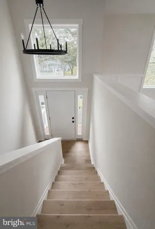 a view of a hallway with wooden floor and cabinet