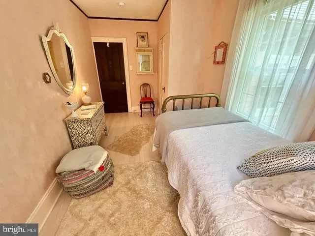 a bedroom with a bed and a large mirror on the dresser