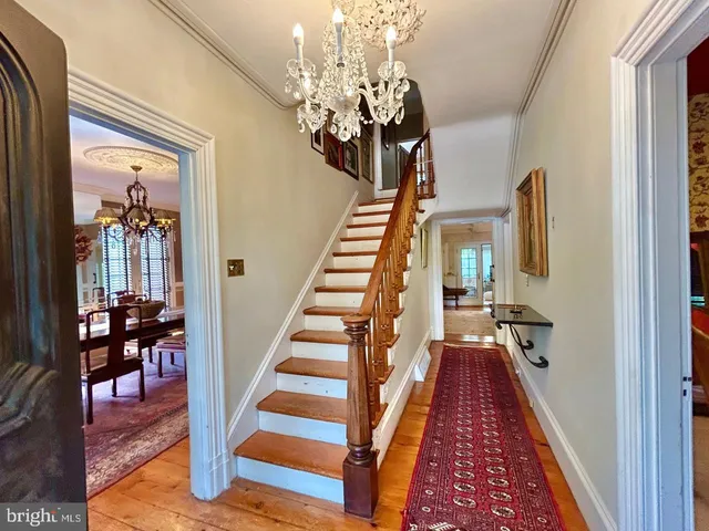 a view of a hallway with wooden floor and staircase
