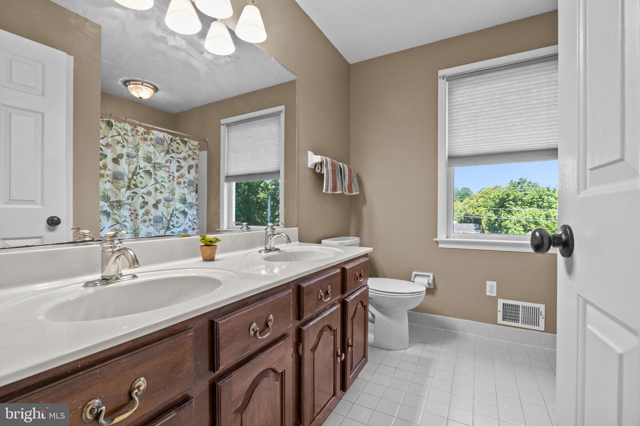 275 West Sandy Ridge Road Doylestown, PA 18901 - Photo 20 of 54 a bathroom with a double vanity sink a toilet and a window