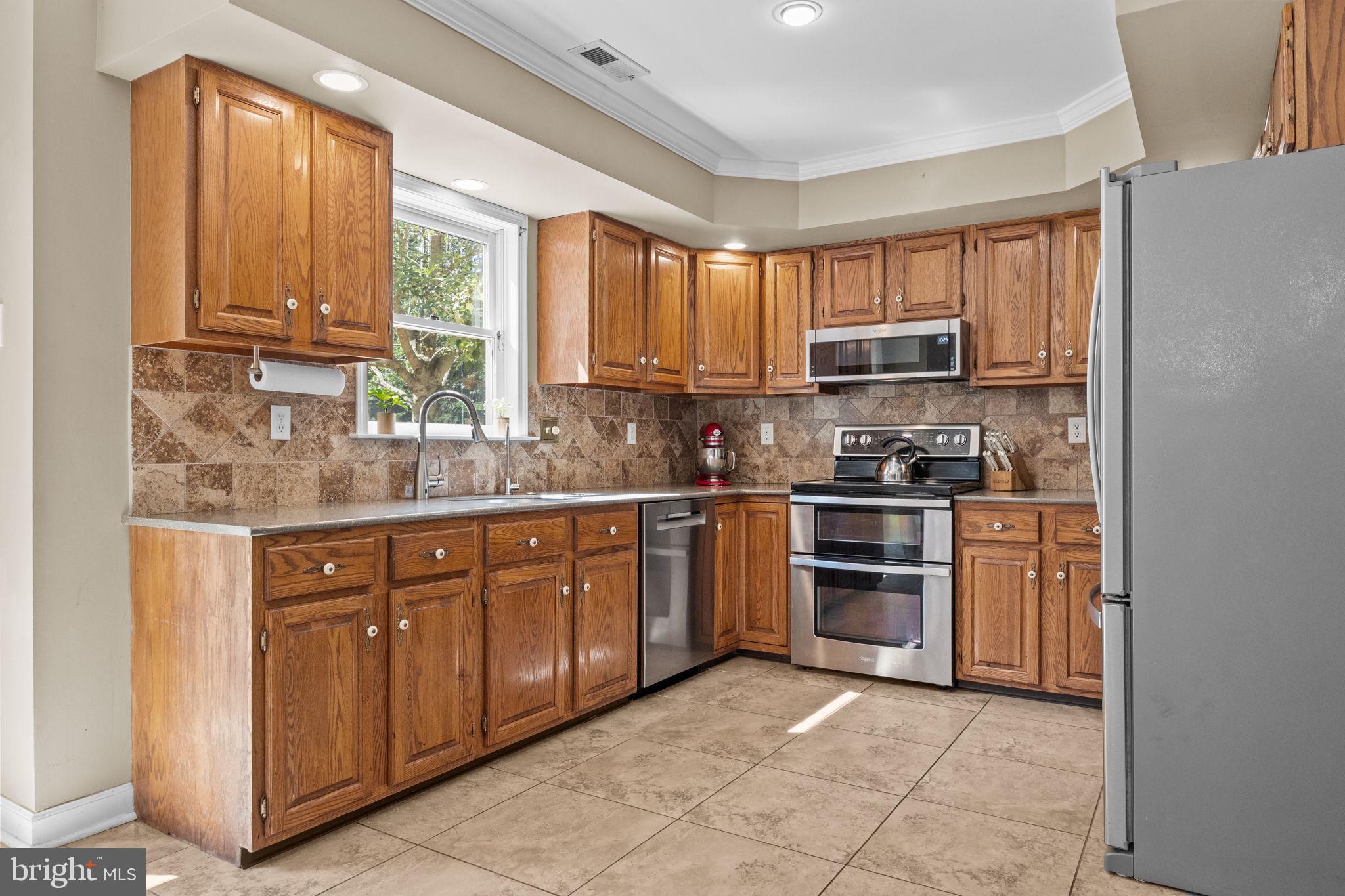 275 West Sandy Ridge Road Doylestown, PA 18901 - Photo 10 of 54 a kitchen with stainless steel appliances granite countertop a stove a sink and white cabinets