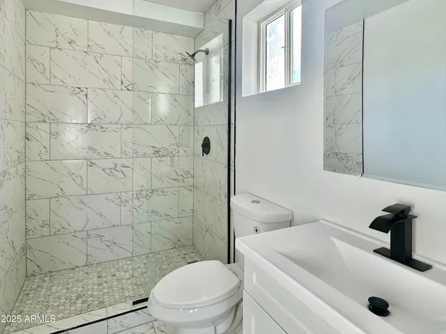 a bathroom with a sink a toilet and shower