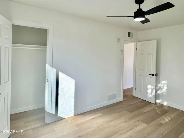 a view of a room with wooden floor closet and windows