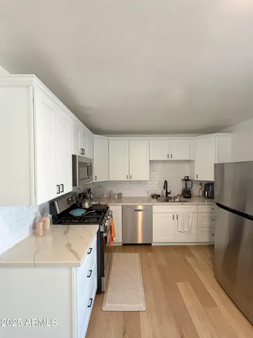 a kitchen with a sink a stove a refrigerator and cabinets