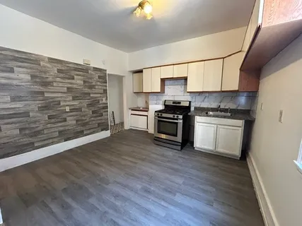 a kitchen with granite countertop a stove top oven a sink and a refrigerator