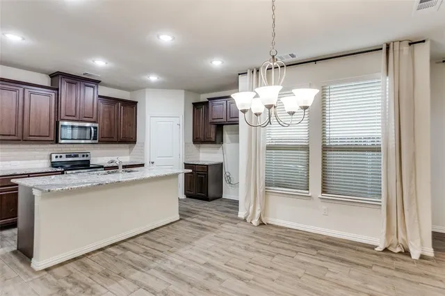 a kitchen that has a lot of cabinets and wooden floor