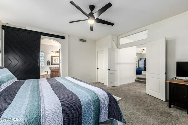 a bedroom with a bed and a flat screen tv