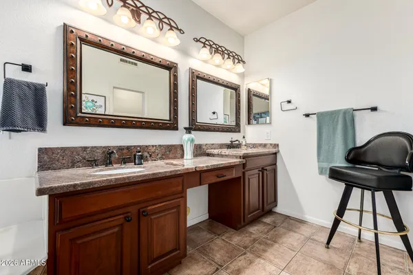 a bathroom with a granite countertop sink a mirror and a window