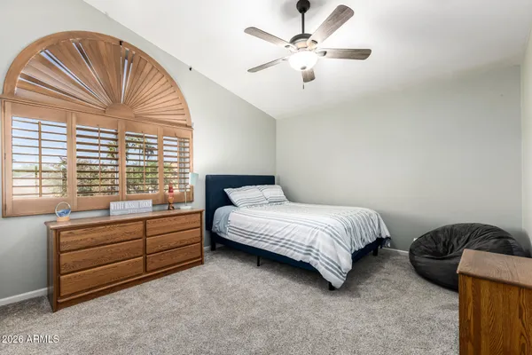 a bedroom with bed and a large window