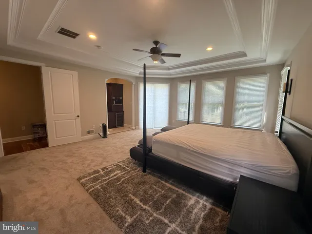 a bedroom with a large bed and a chandelier