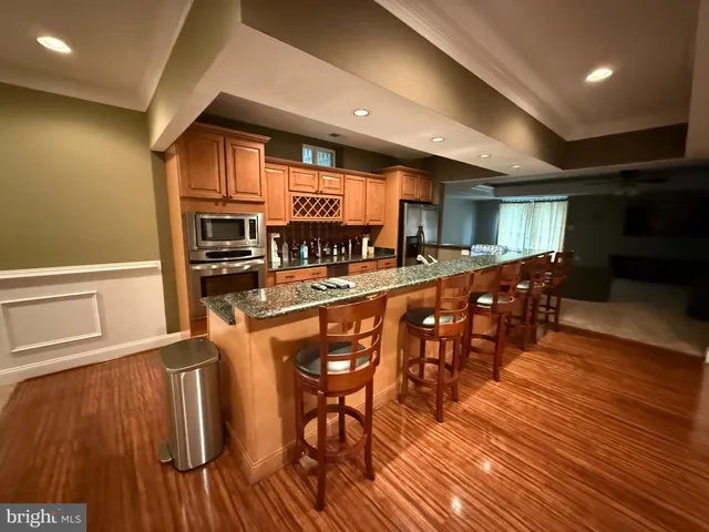 a kitchen with stainless steel appliances granite countertop a stove and a wooden floors