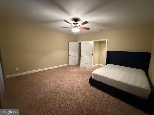 a bedroom with a large bed and a ceiling fan