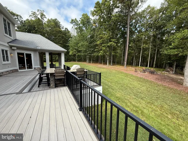 a view of a deck with chairs and a yard with wooden floor