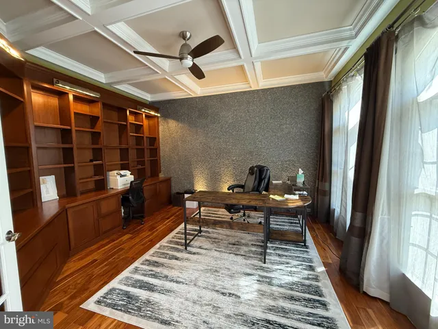 a reading room with wooden floor pool table and windows
