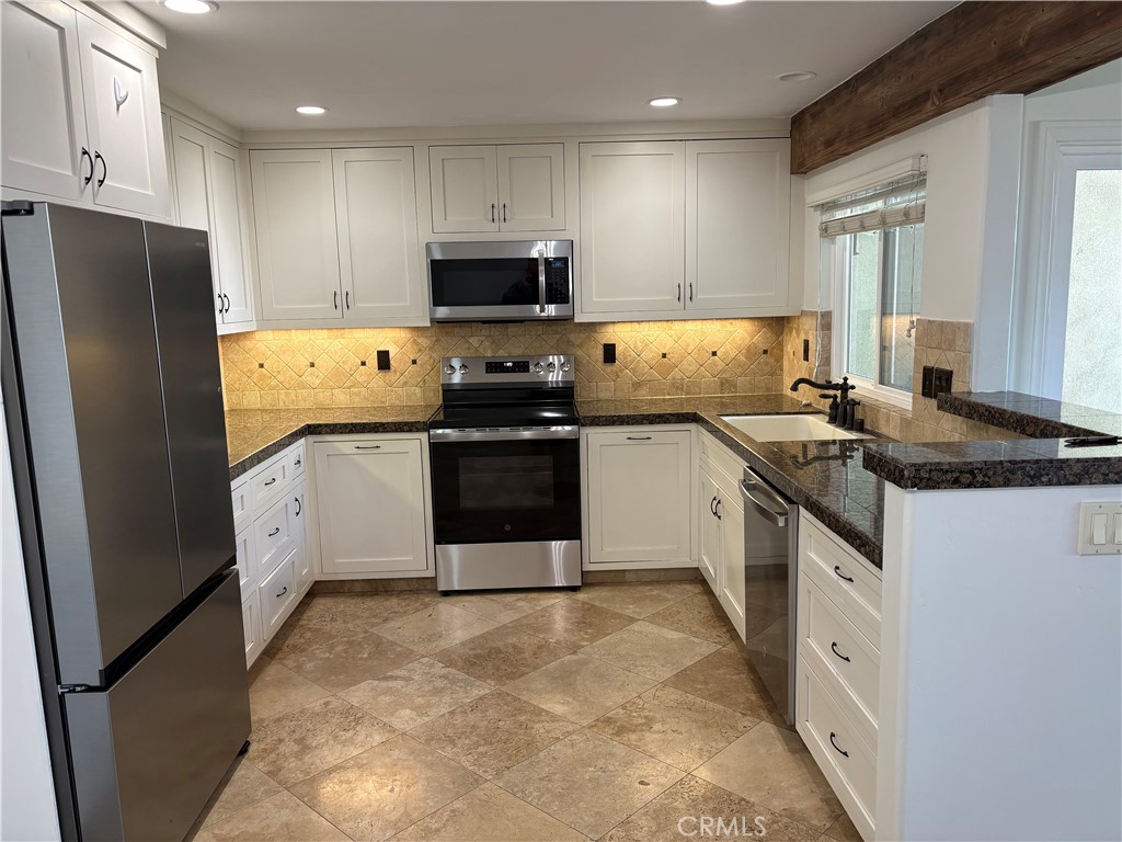 34132 Selva Road, Unit 250 Dana Point, CA 92629 - Photo 3 of 25 a kitchen with stainless steel appliances granite countertop a stove top oven a refrigerator a sink and dishwasher