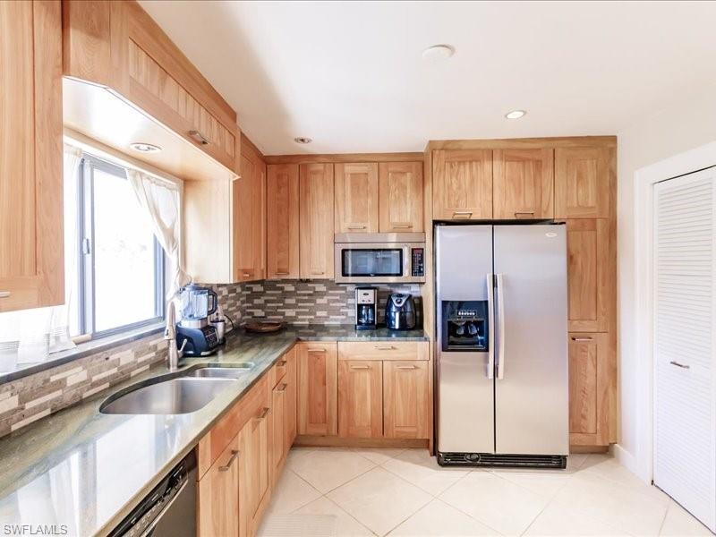 910 Vanderbilt Beach Road, Unit 524W Naples, FL 34108 - Photo 12 of 44 Kitchen featuring stainless steel appliances, sink, tasteful backsplash, and light tile floors
