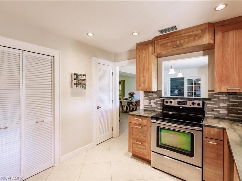 910 Vanderbilt Beach Road, Unit 524W Naples, FL 34108 - Photo 10 of 44 Kitchen featuring electric stove, tasteful backsplash, and light tile floors