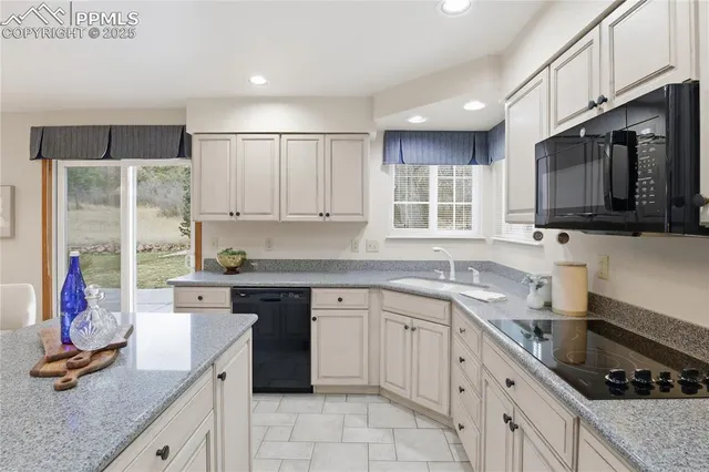 a kitchen with kitchen island granite countertop a sink stainless steel appliances and cabinets