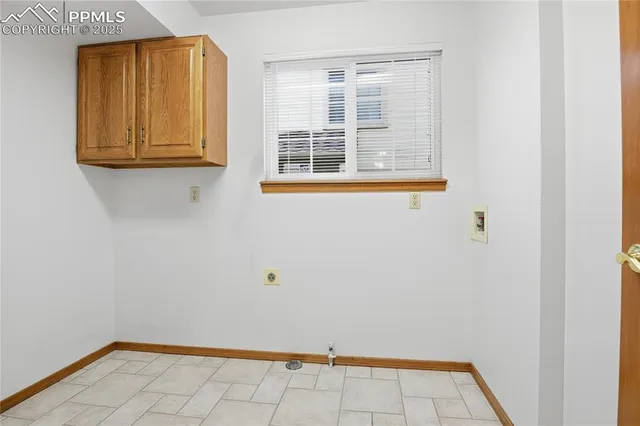 a view of an empty room with wooden floor and windows