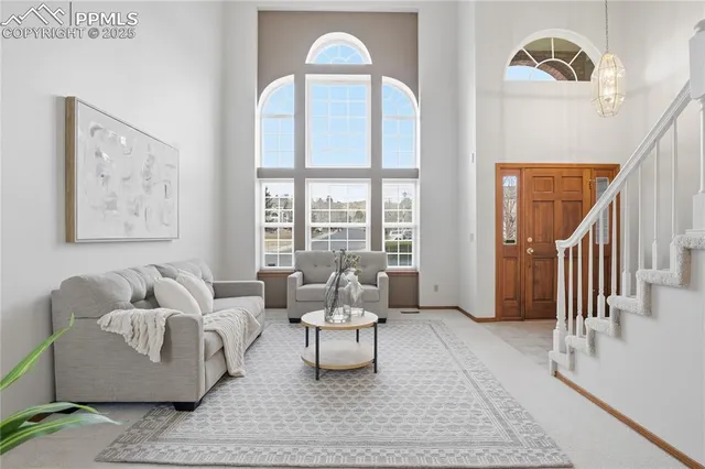 a living room with furniture and a floor to ceiling window