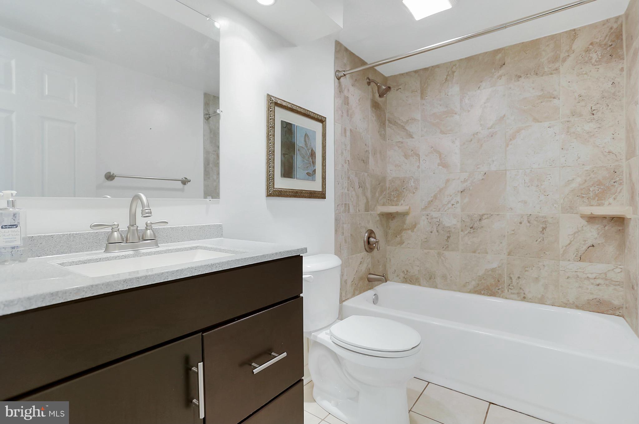 220 W Road Baltimore, MD 21221 - Photo 21 of 30 a bathroom with a sink a toilet a mirror a bathtub and shower