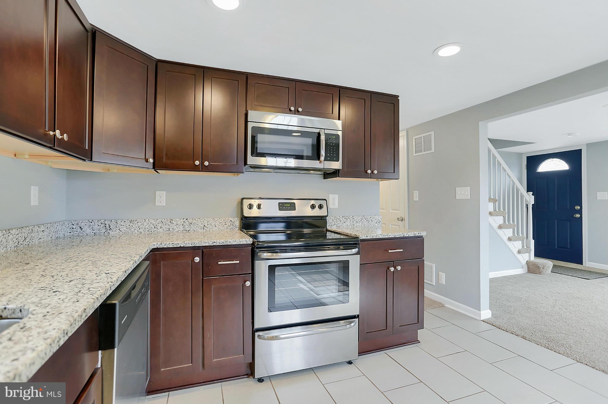 220 W Road Baltimore, MD 21221 - Photo 9 of 30 a kitchen with stainless steel appliances granite countertop wooden cabinets a stove top oven a sink and dishwasher