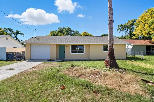 a view of a house with a yard and potted plants