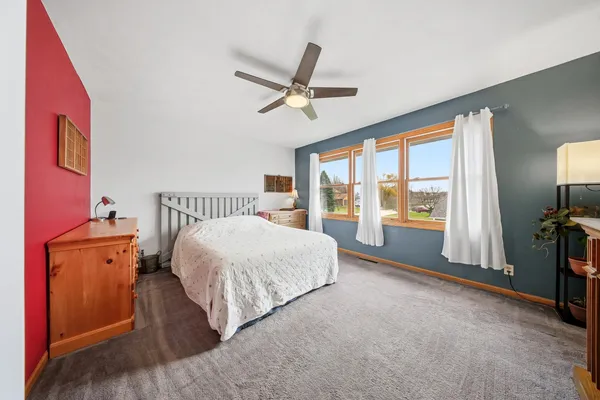 a spacious bedroom with a bed and a large window