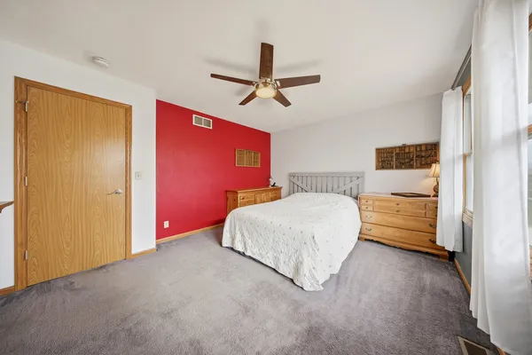 a bedroom with a bed dresser and a window