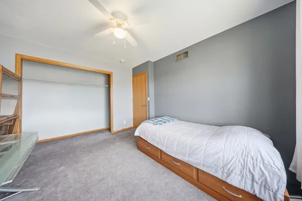 a bedroom with a bed and a ceiling fan