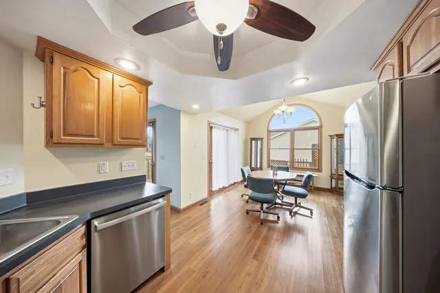 a kitchen with stainless steel appliances a dining table chairs stove and refrigerator