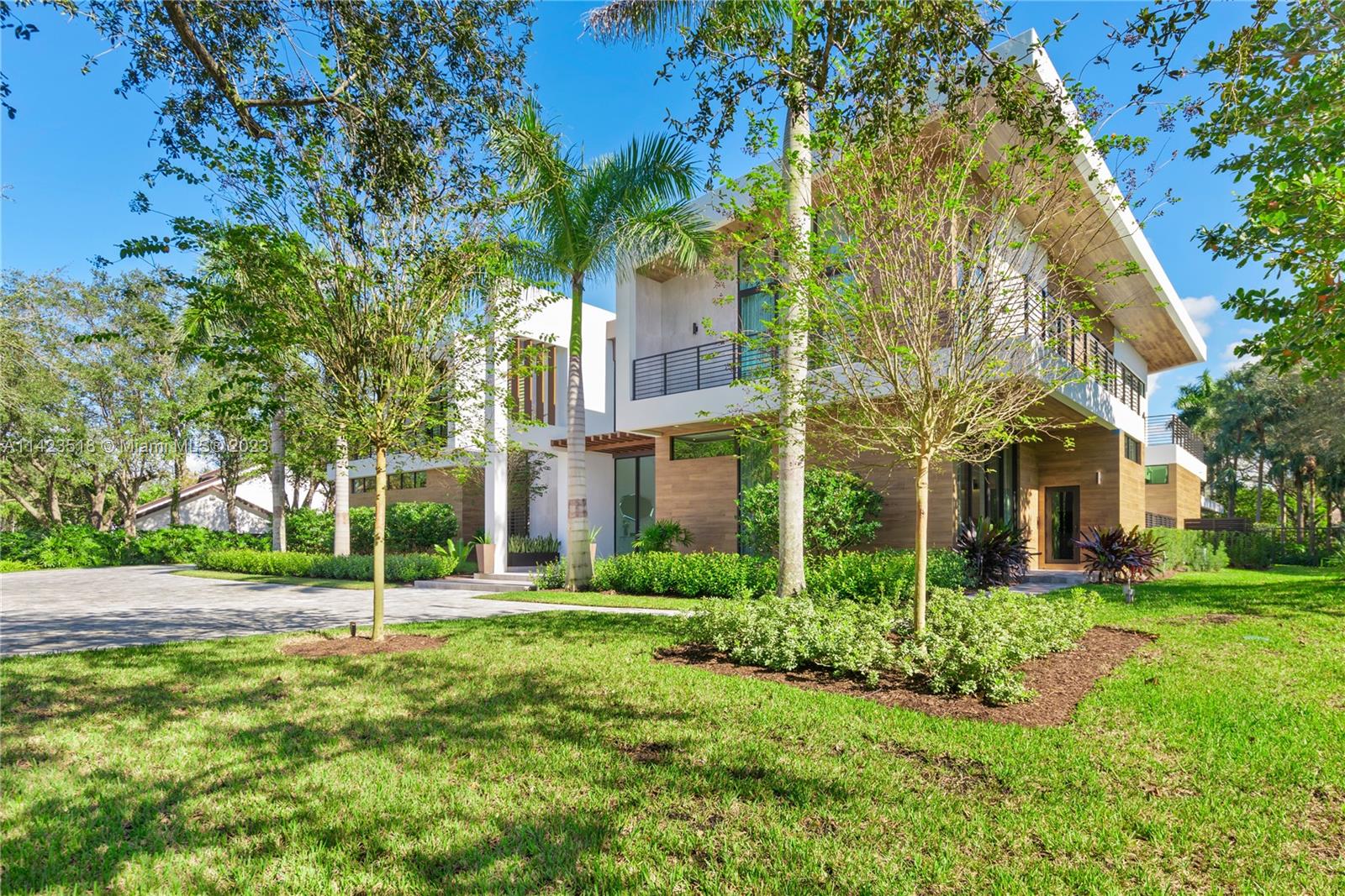 2690 Hackney Road Weston, FL 33331 - Photo 15 of 88 a view of a white house next to a yard with big trees