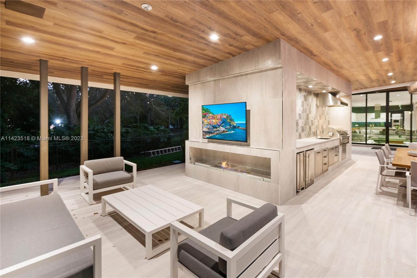 2690 Hackney Road Weston, FL 33331 - Photo 80 of 88 a living room with furniture a flat screen tv and a floor to ceiling window