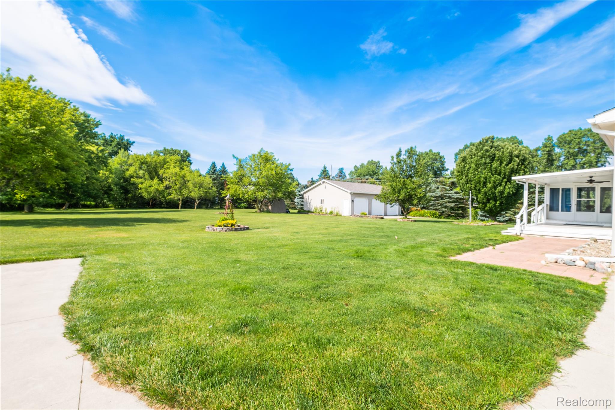 9600 Hamill Road Otisville, MI 48463 - Photo 27 of 32 Expansive green lawn with mature trees and a three-car detached garage
