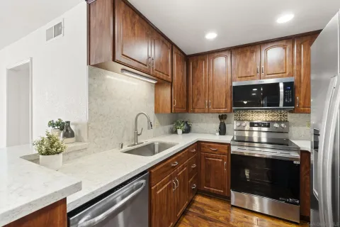 a kitchen with stainless steel appliances a sink stove and microwave