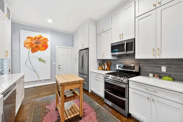 a kitchen with stainless steel appliances granite countertop a stove a sink and a microwave