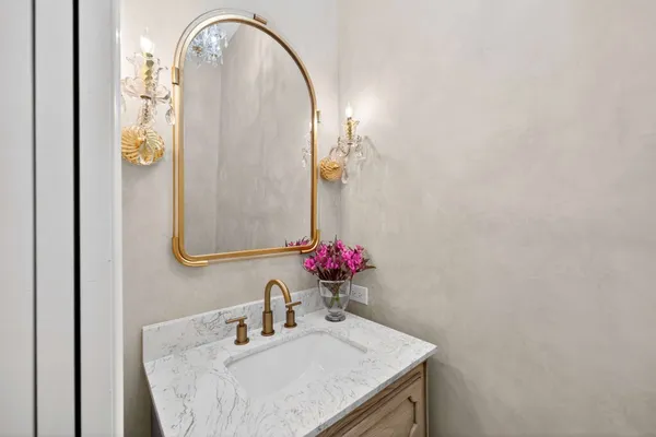a bathroom with a granite countertop sink and a mirror